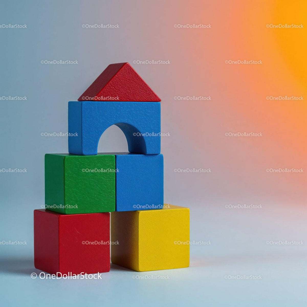 Stack of colorful wooden toy blocks with red triangular top block and arch-shaped blue block below