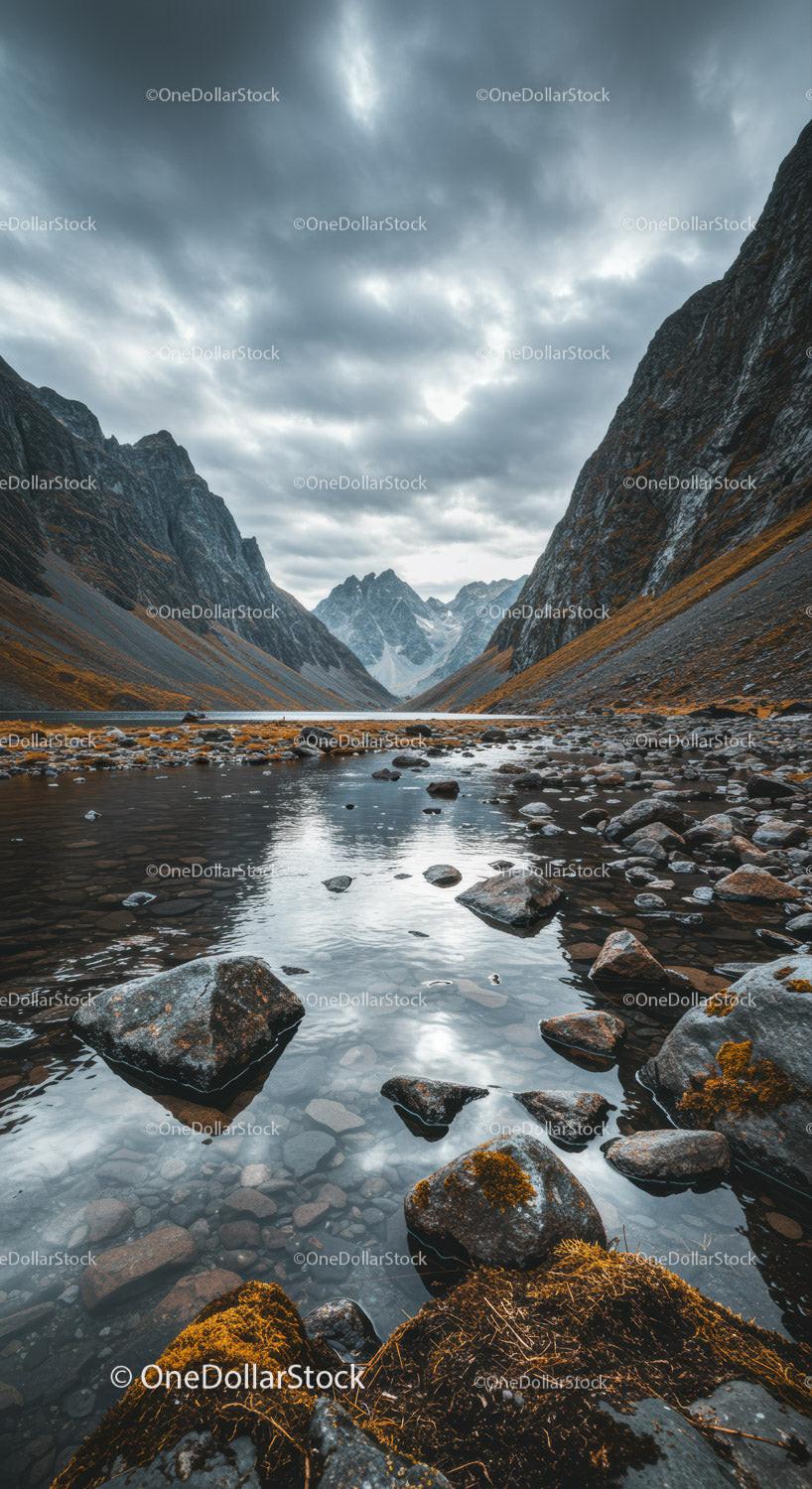 Rocky Mountain Valley with Reflective Water and Overcast Sky