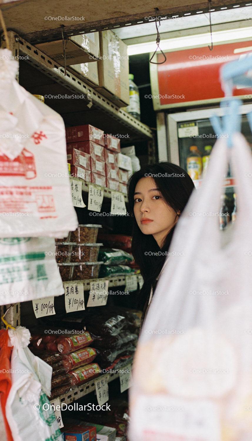 Young woman shopping in cozy Asian market aisle