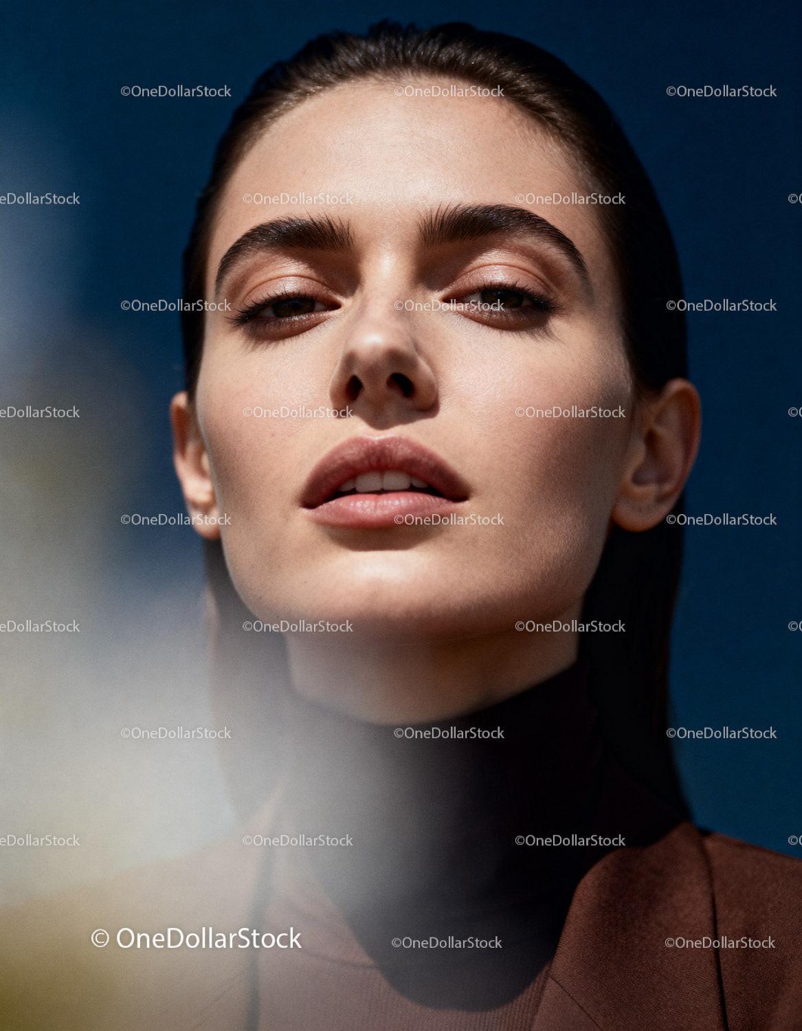 Confident woman with natural makeup against blue sky