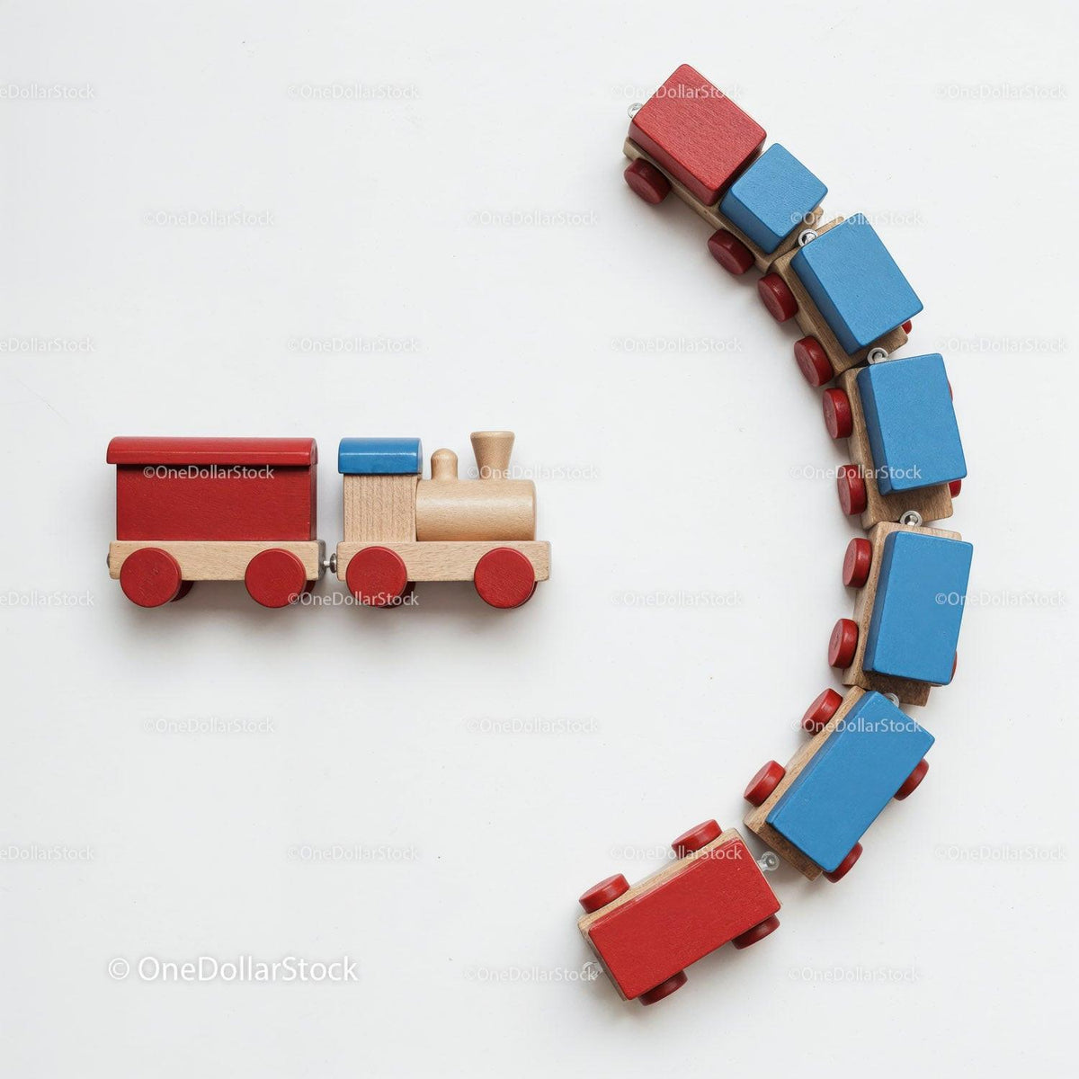 Wooden toy train with red wheels and blue and red rectangular cars on white background