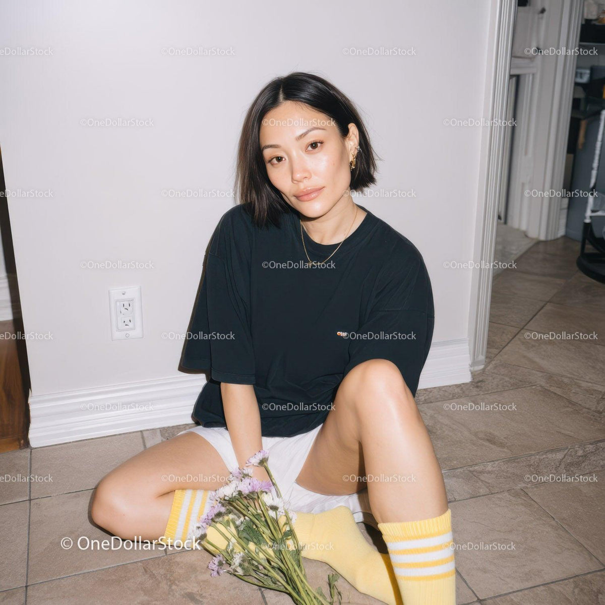 Portrait of a Stylish Young Woman Sitting on the Floor in Casual Outfit