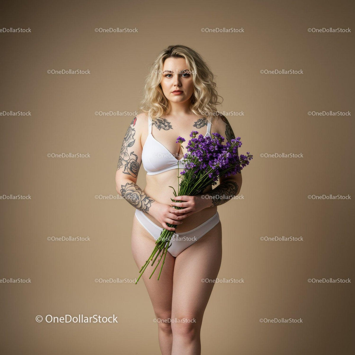 Portrait of a Tattooed Woman Holding Purple Flowers in Lingerie Studio