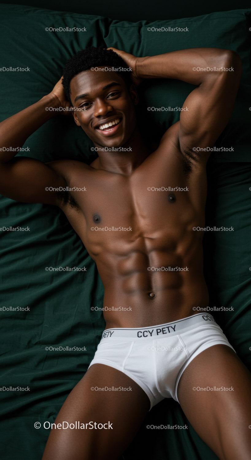 Smiling young man relaxing on bed in white briefs