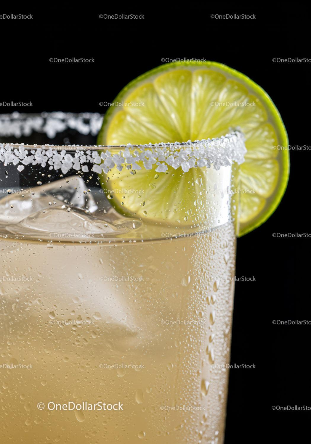 Refreshing cocktail with salted rim and lime wedge