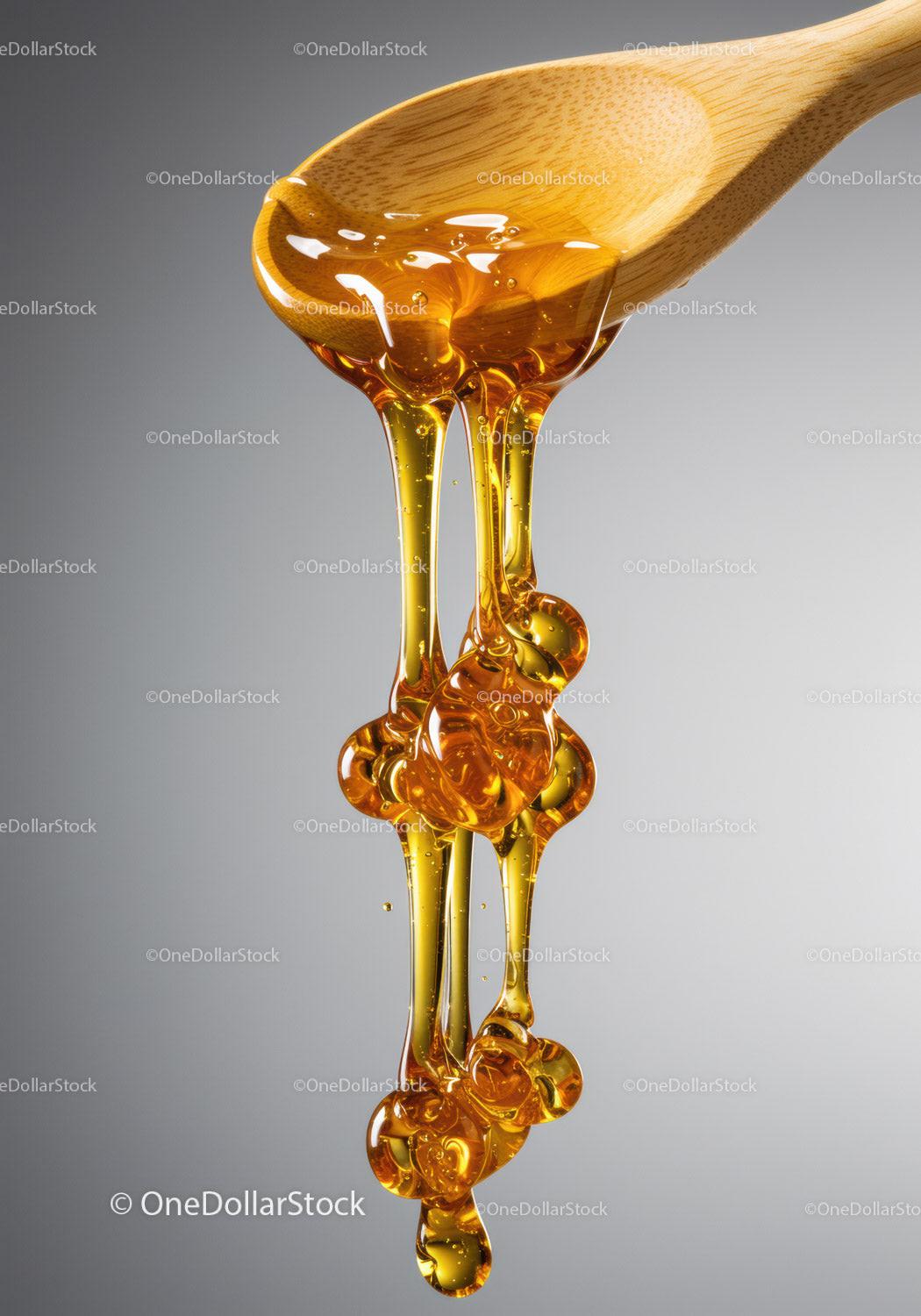 Golden honey dripping from wooden spoon closeup