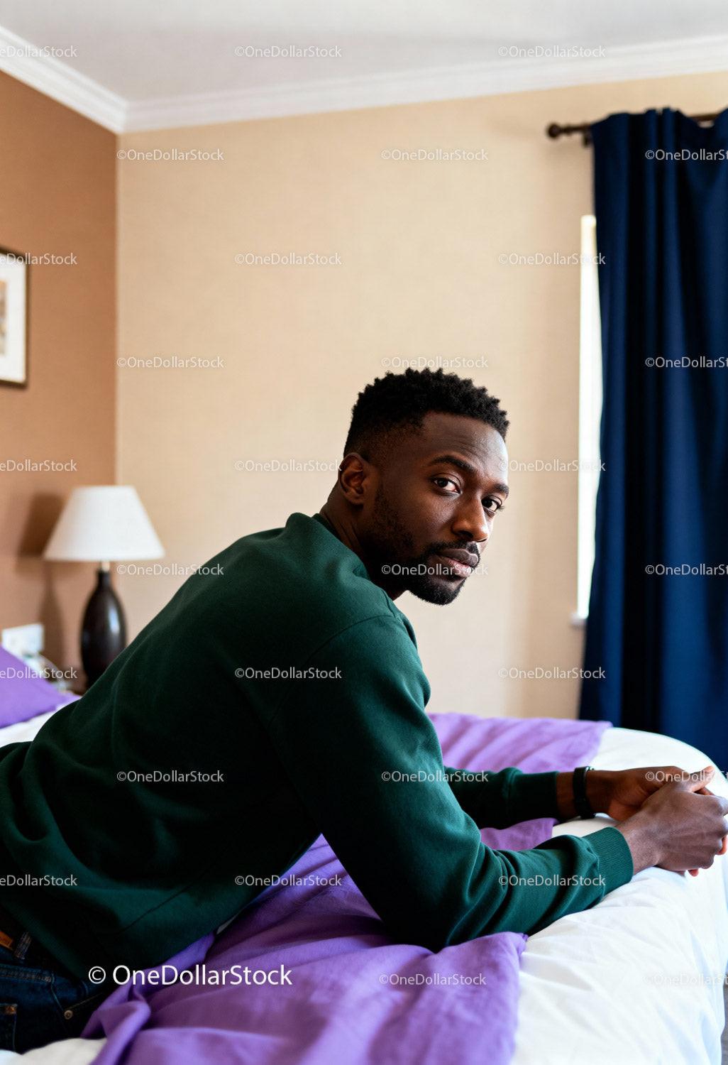 Thoughtful man relaxing on bed in softly lit room