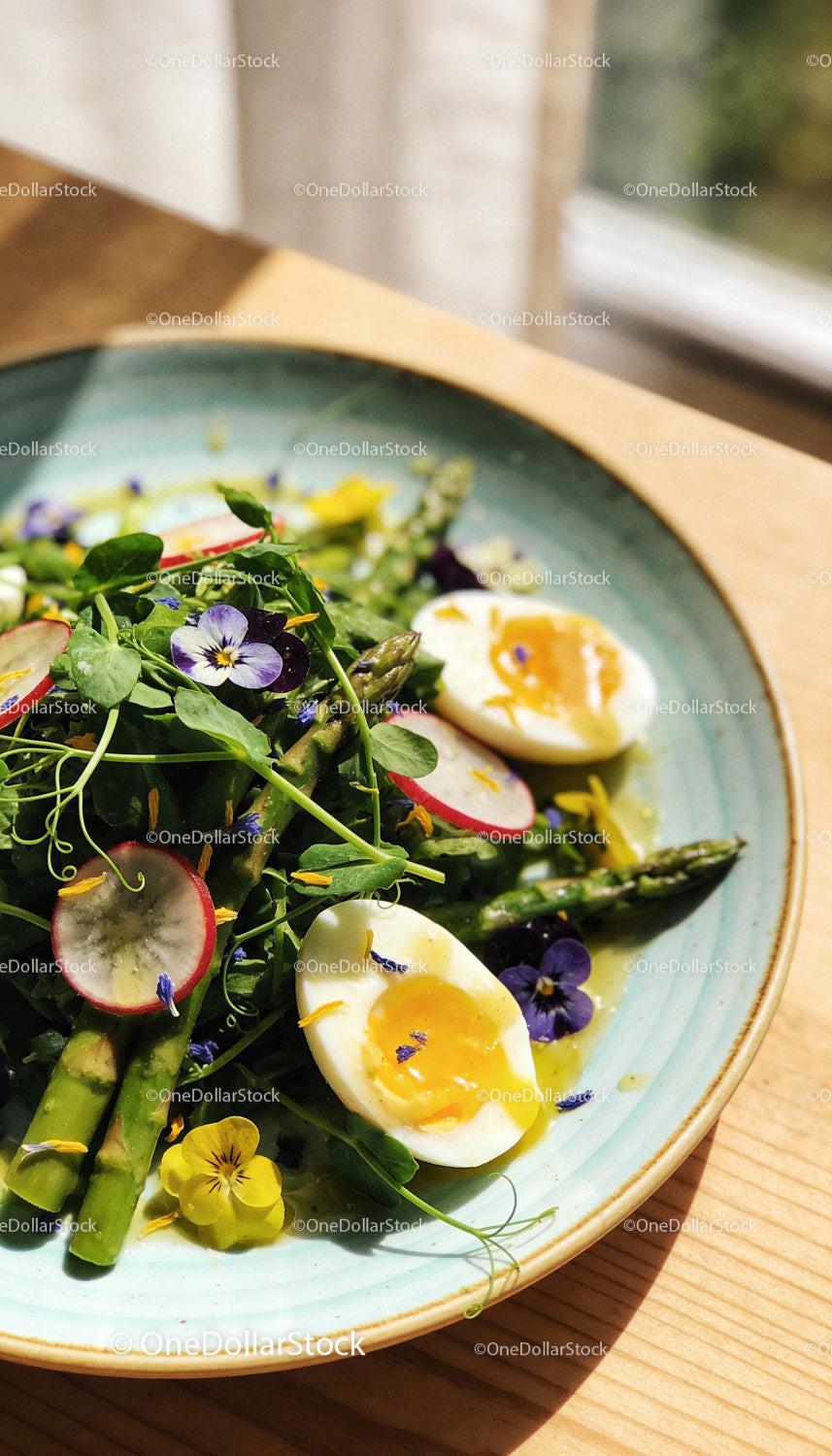 Fresh spring salad with asparagus, eggs, and edible flowers