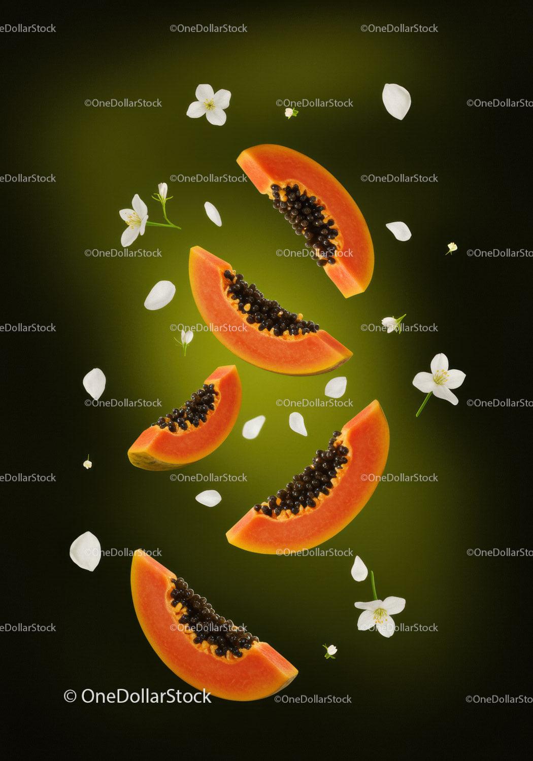 Fresh papaya slices with delicate white flowers on green