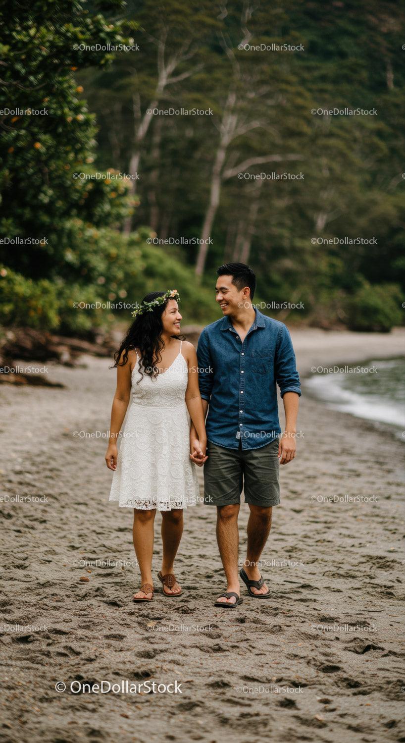 Romantic Young Couple Walking Hand in Hand on Beach at Sunset