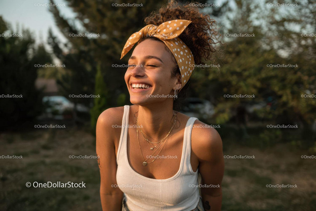 Joyful Young Woman Laughing Outdoors in Summer Clothing and Polka Dot Headscarf