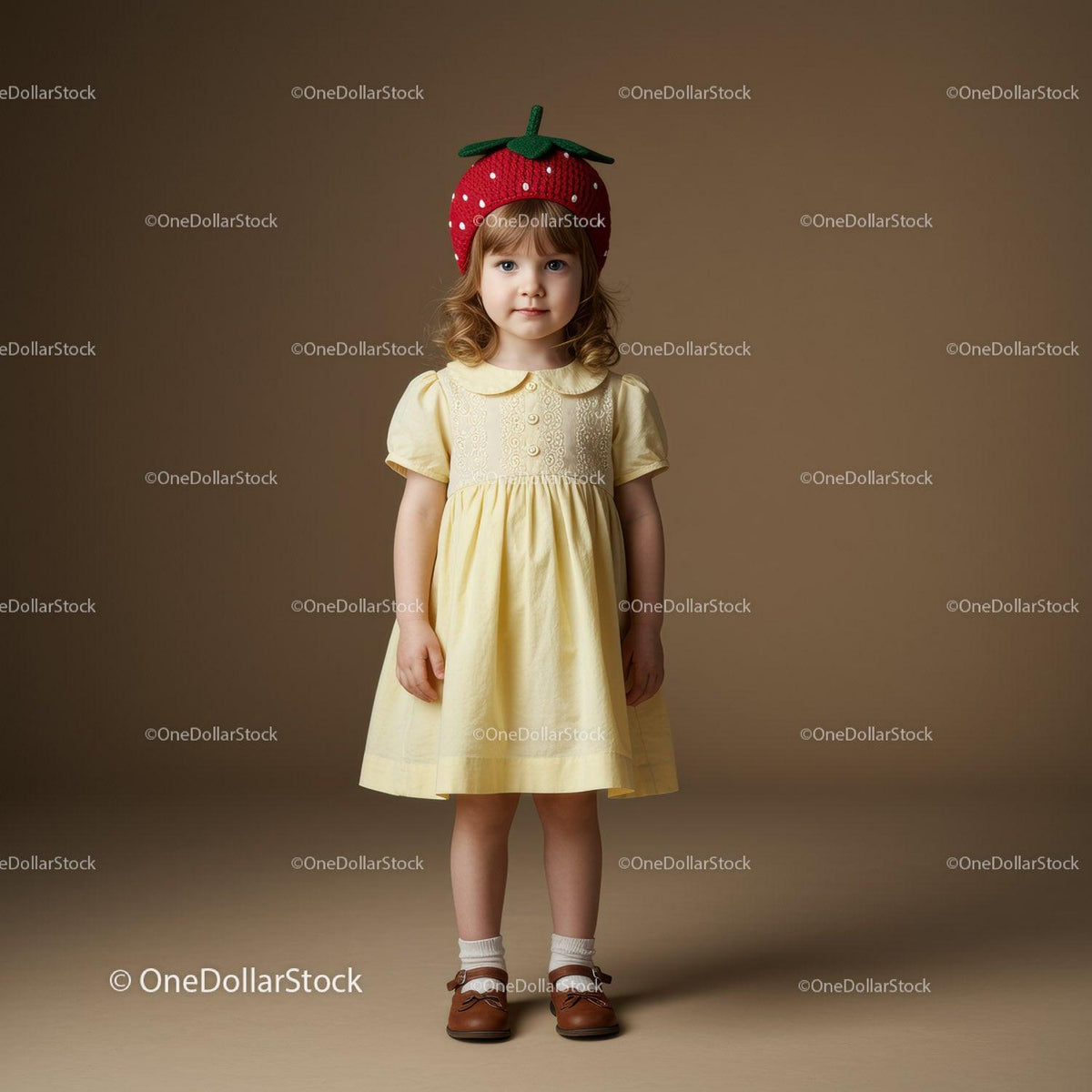 Little girl in yellow dress with strawberry hat