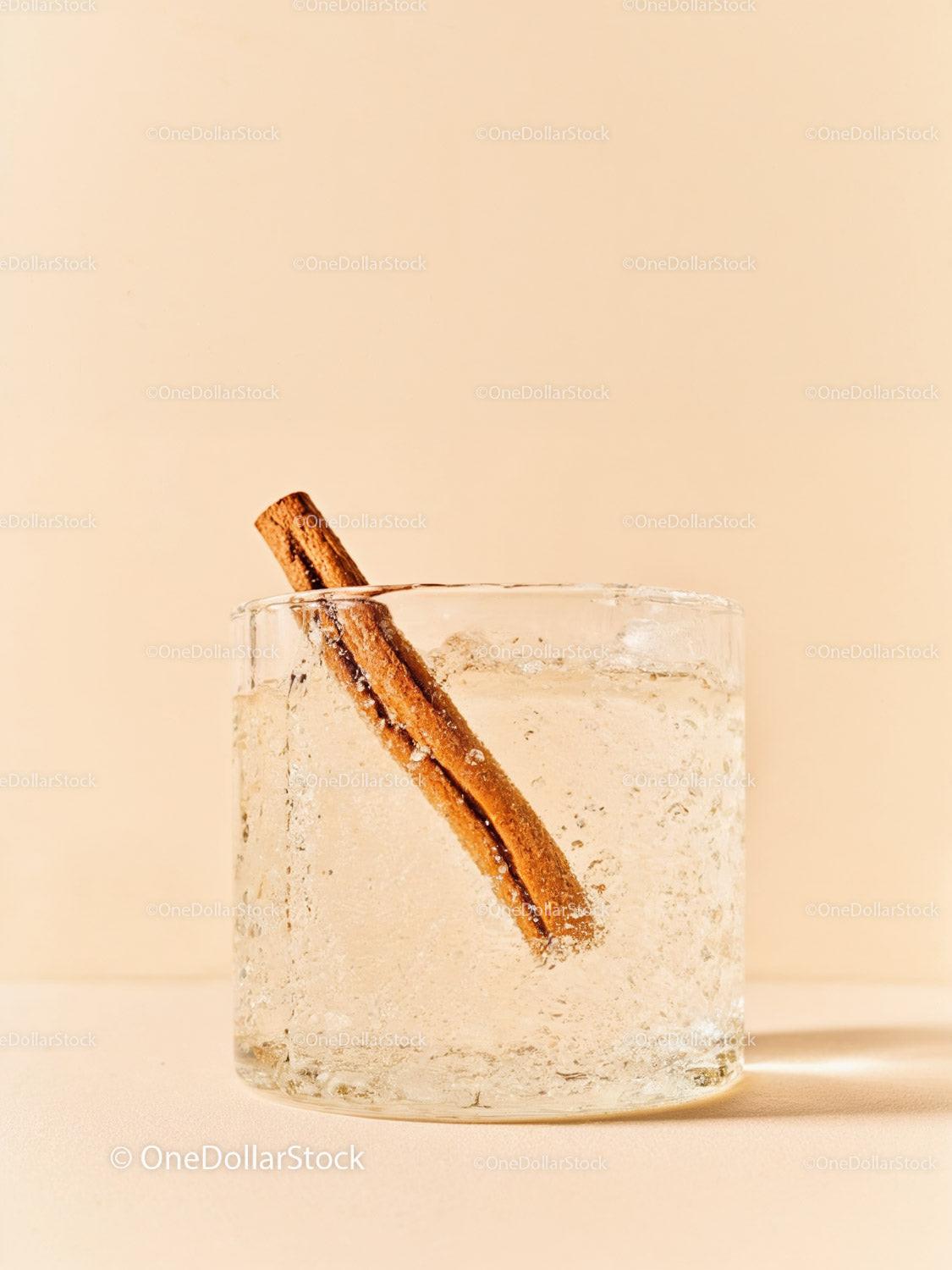 Refreshing clear drink with cinnamon stick in glass