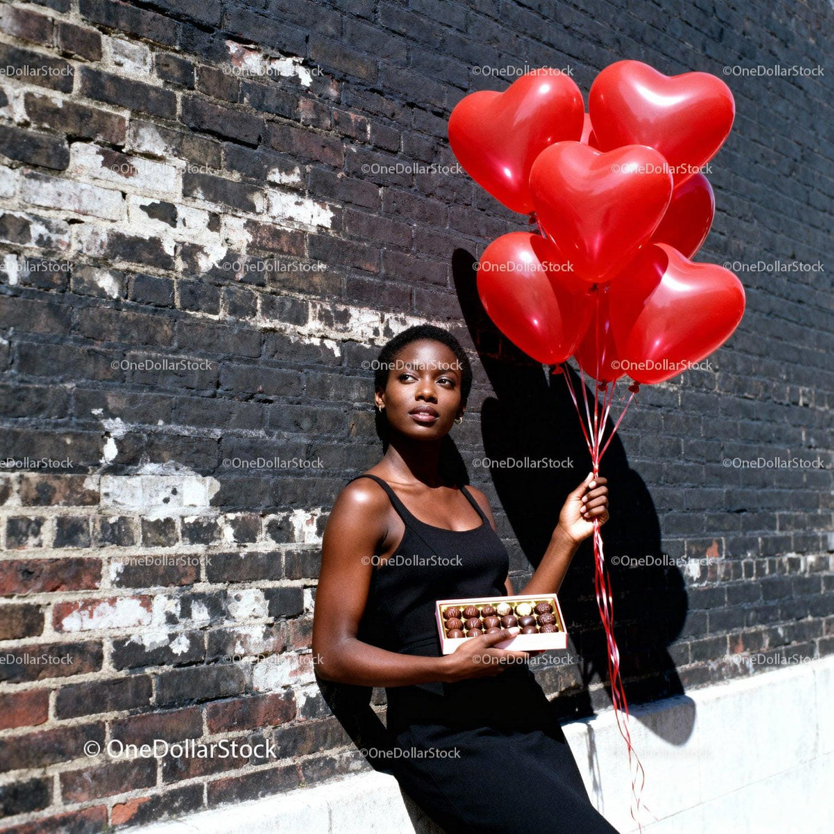Woman Holding Heart Balloons and Chocolates by Brick Wall