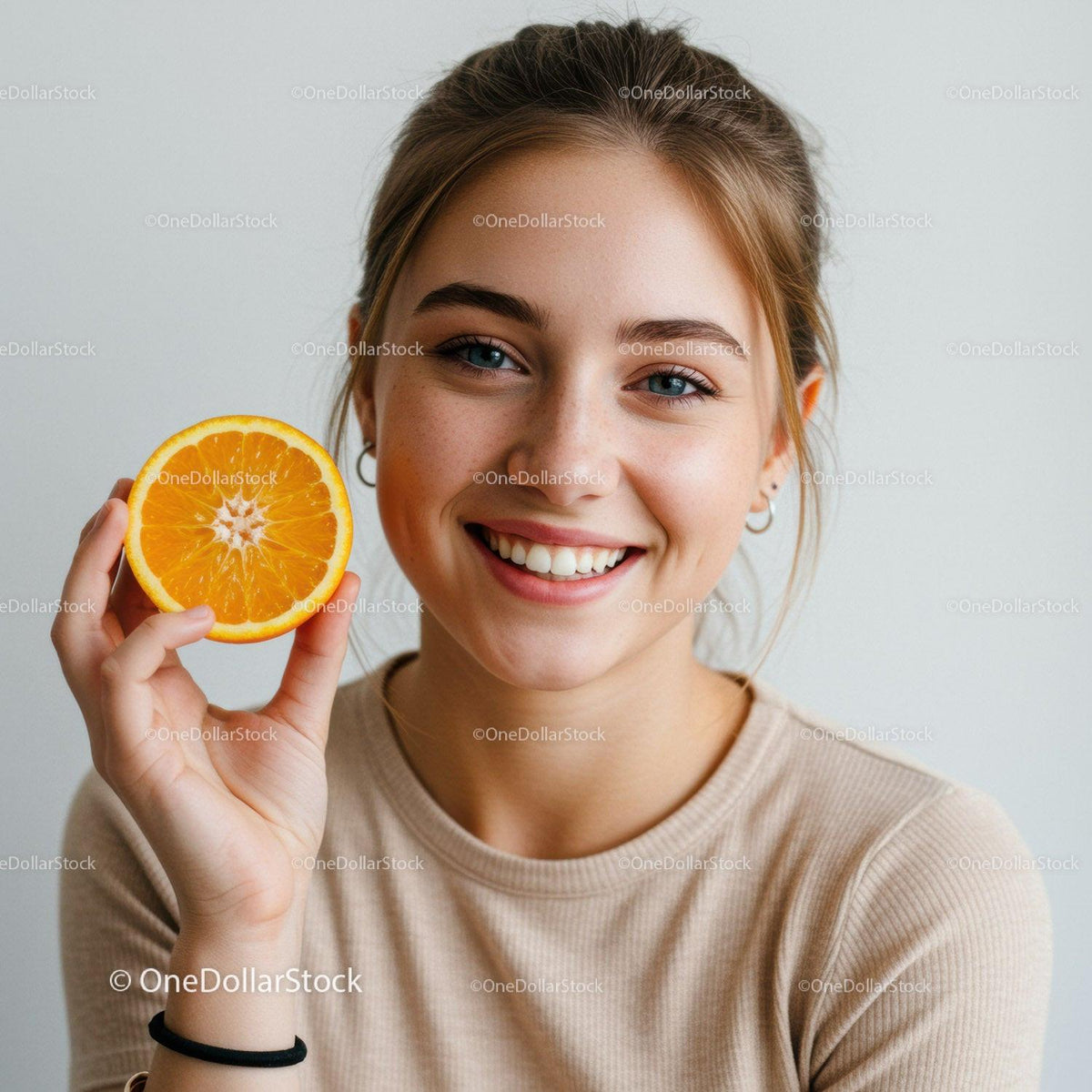 Smiling Woman Holding Fresh Orange Slice in Bright Portrait