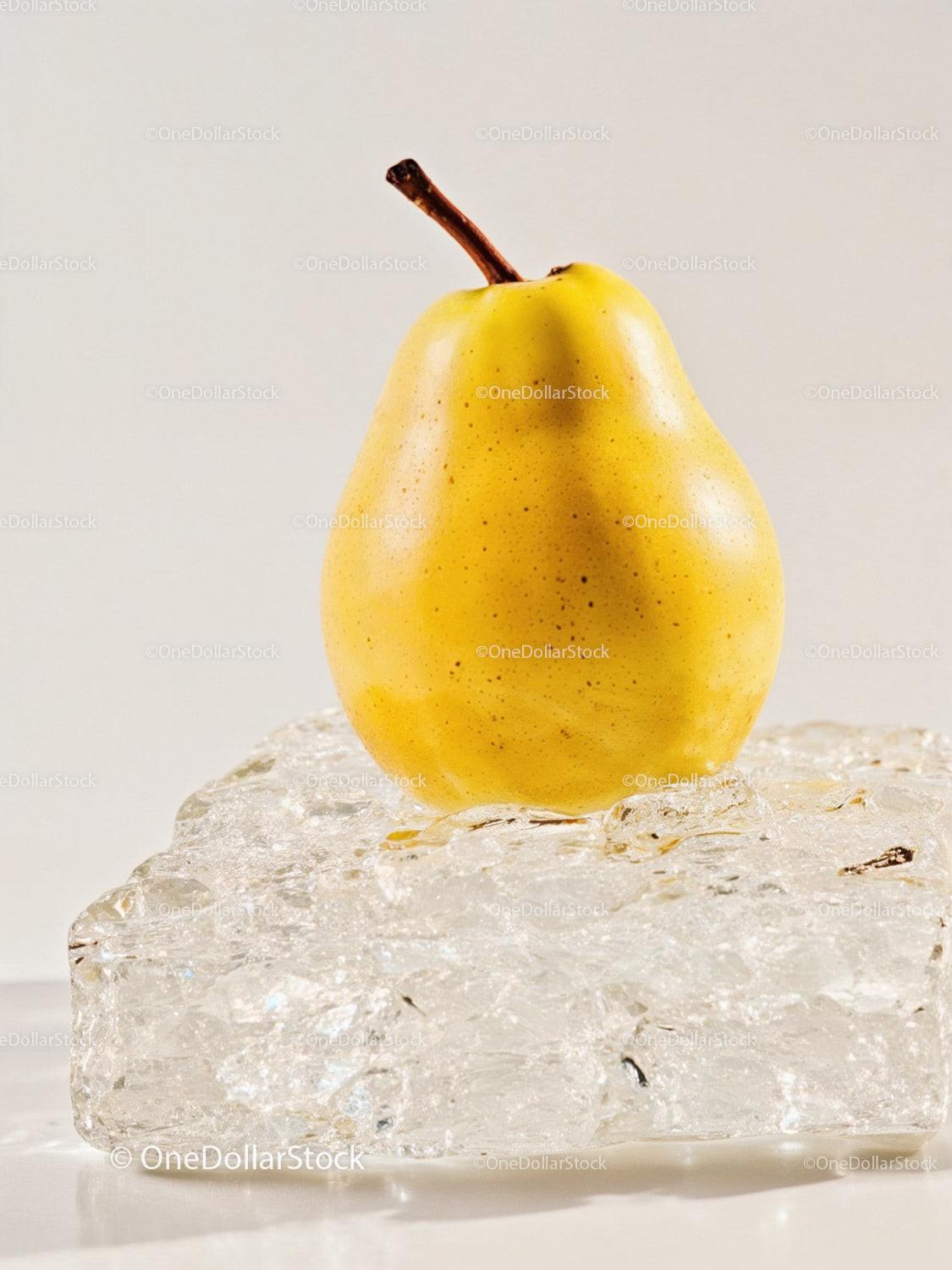 Fresh yellow pear resting on textured ice block