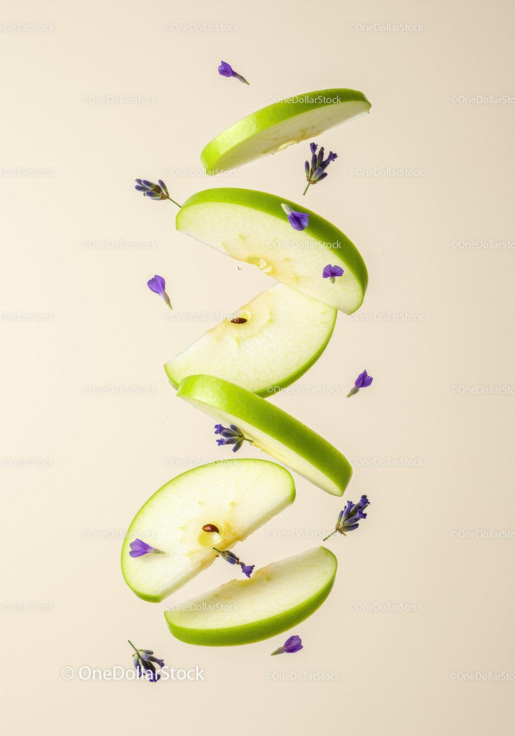 Fresh green apple slices with delicate purple flowers