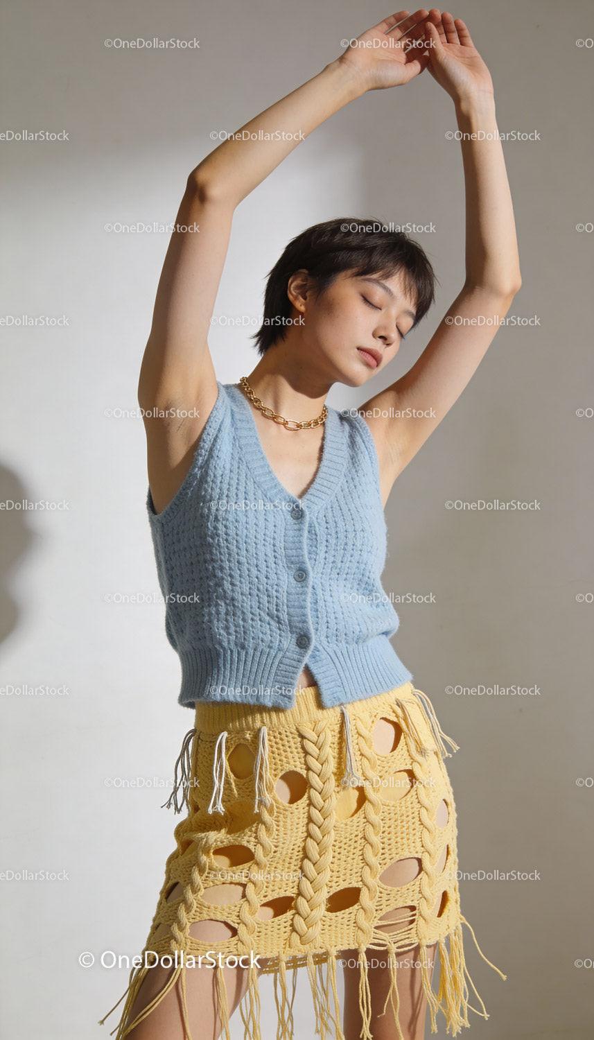 Young woman in knitted blue top and yellow skirt