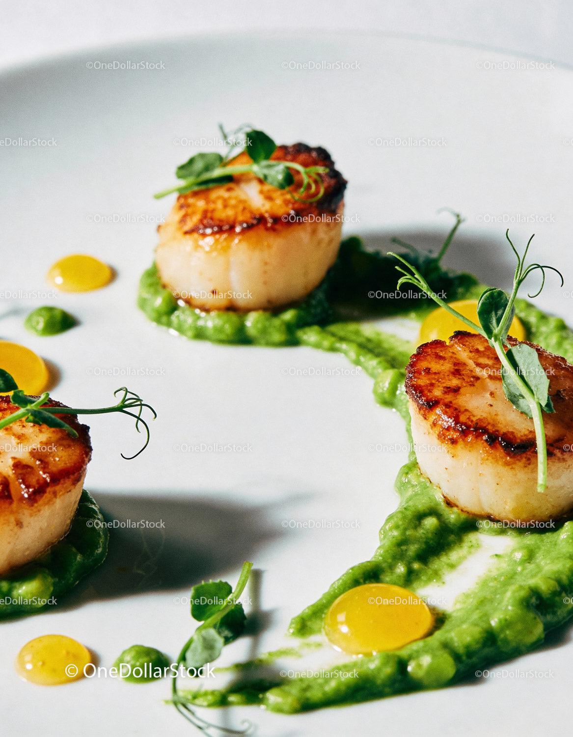 Seared scallops with green pea puree and microgreens
