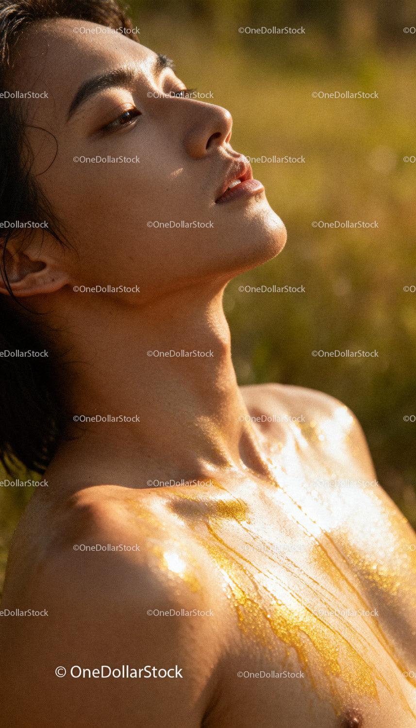 Close up of woman with golden body paint in sunlight