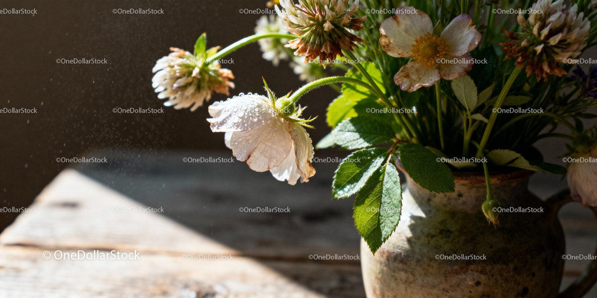 Delicate wildflowers in rustic ceramic vase with morning dew