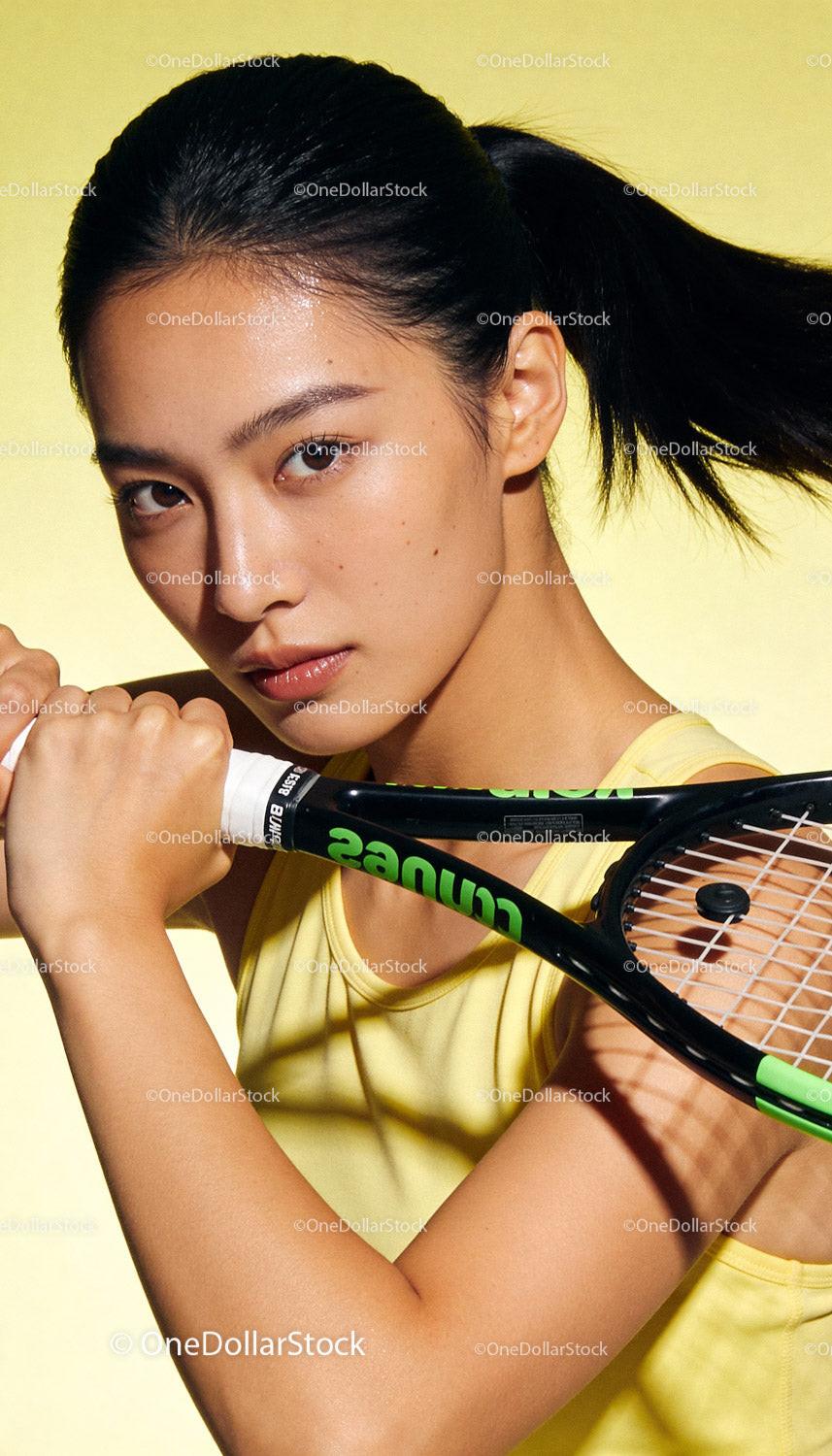 Focused young female tennis player with racket in hand