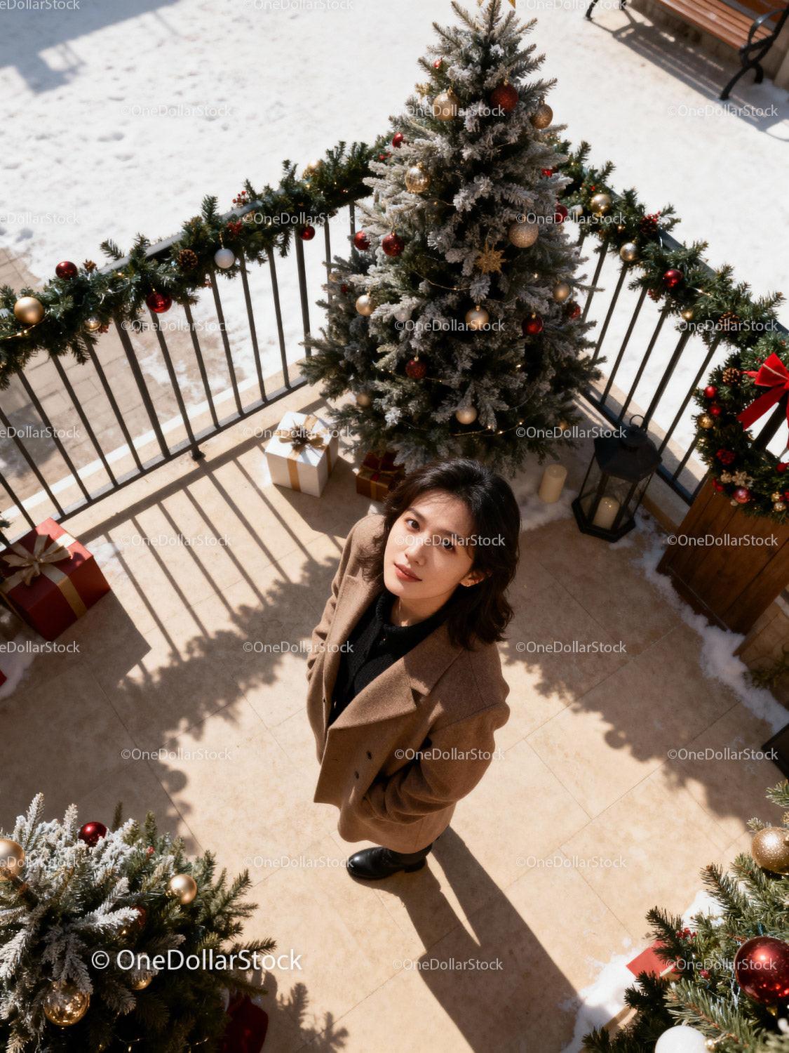 Young woman standing on decorated balcony with Christmas tree