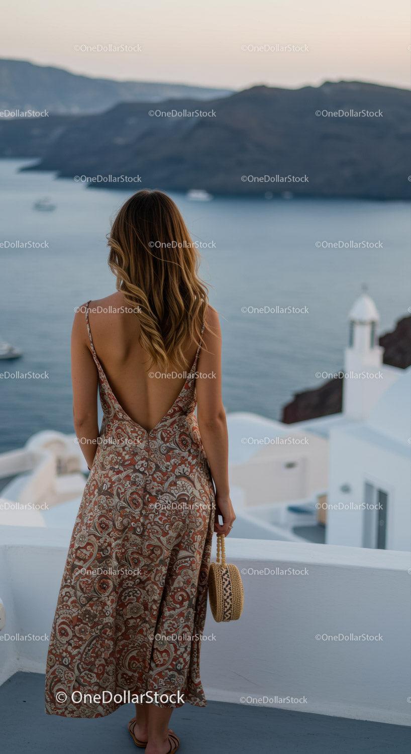 Woman in patterned dress overlooking sea and cliffs