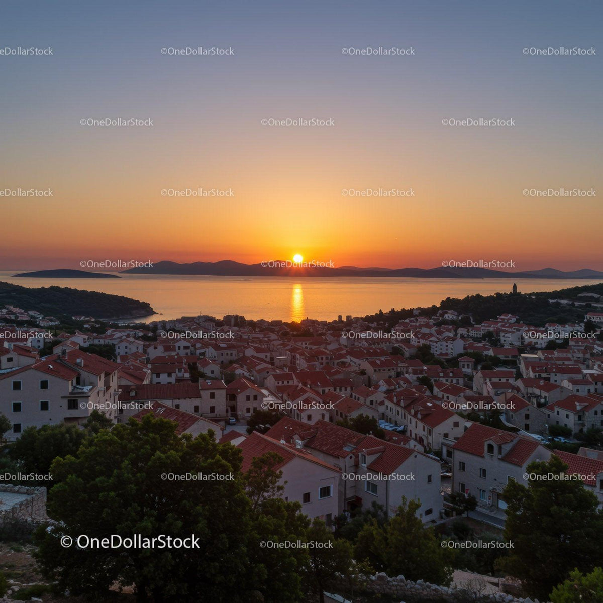 Scenic Sunset Over Coastal Town With Red Rooftops and Seaside Views