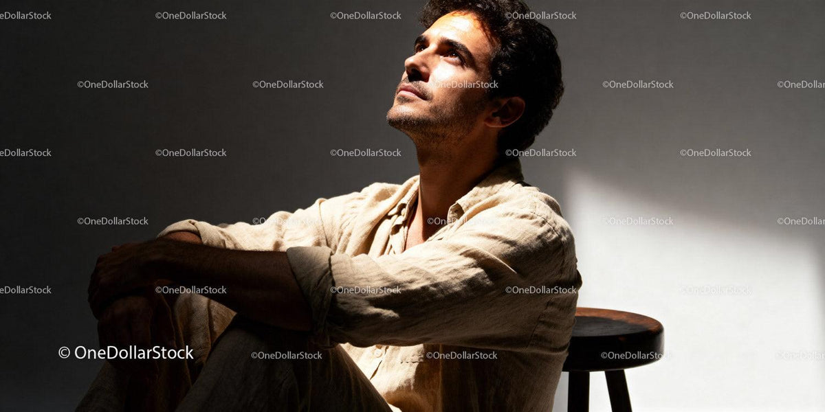 Thoughtful man sitting solo in warm natural light