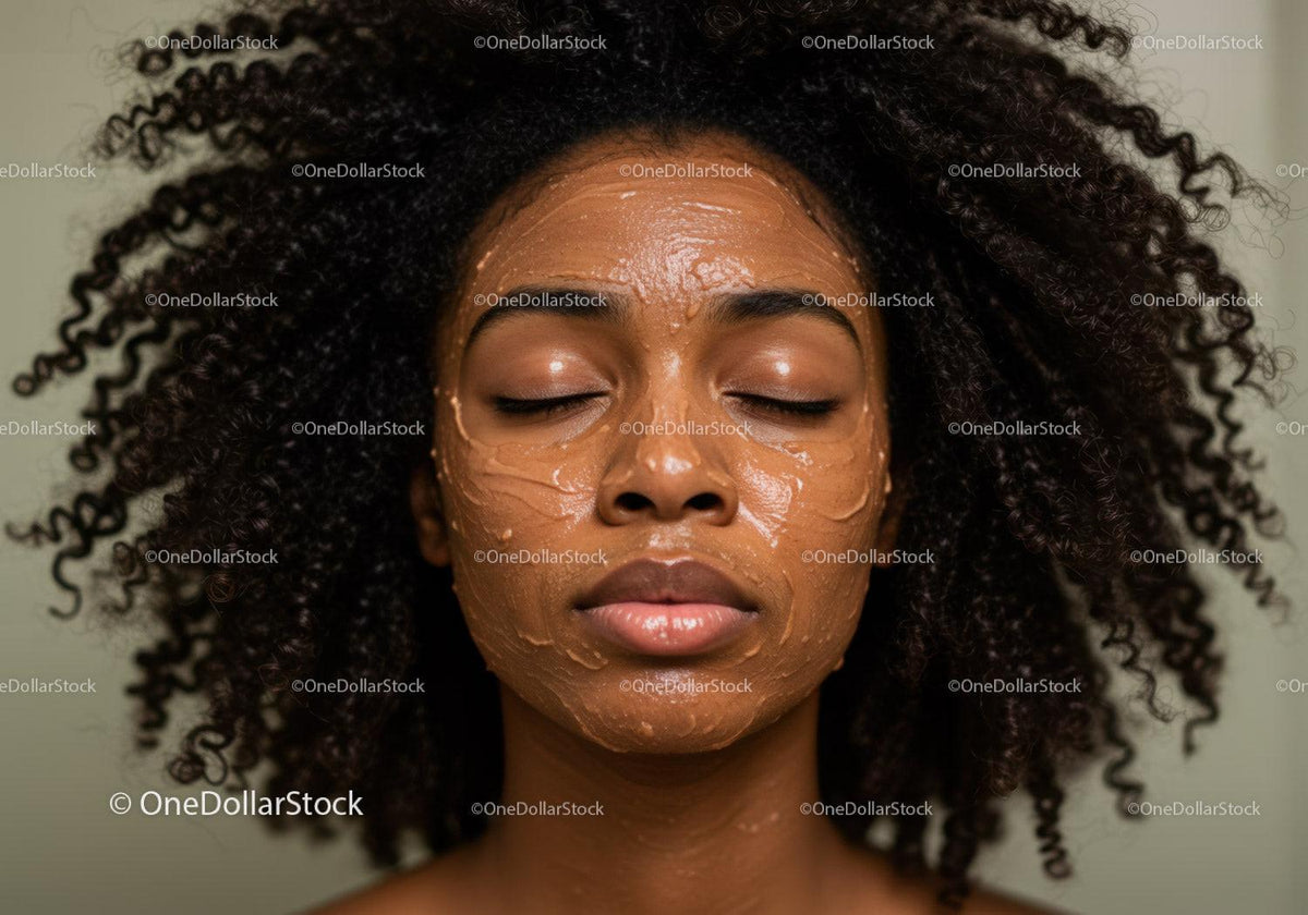 Close-up of a woman with natural curly hair applying facial mask