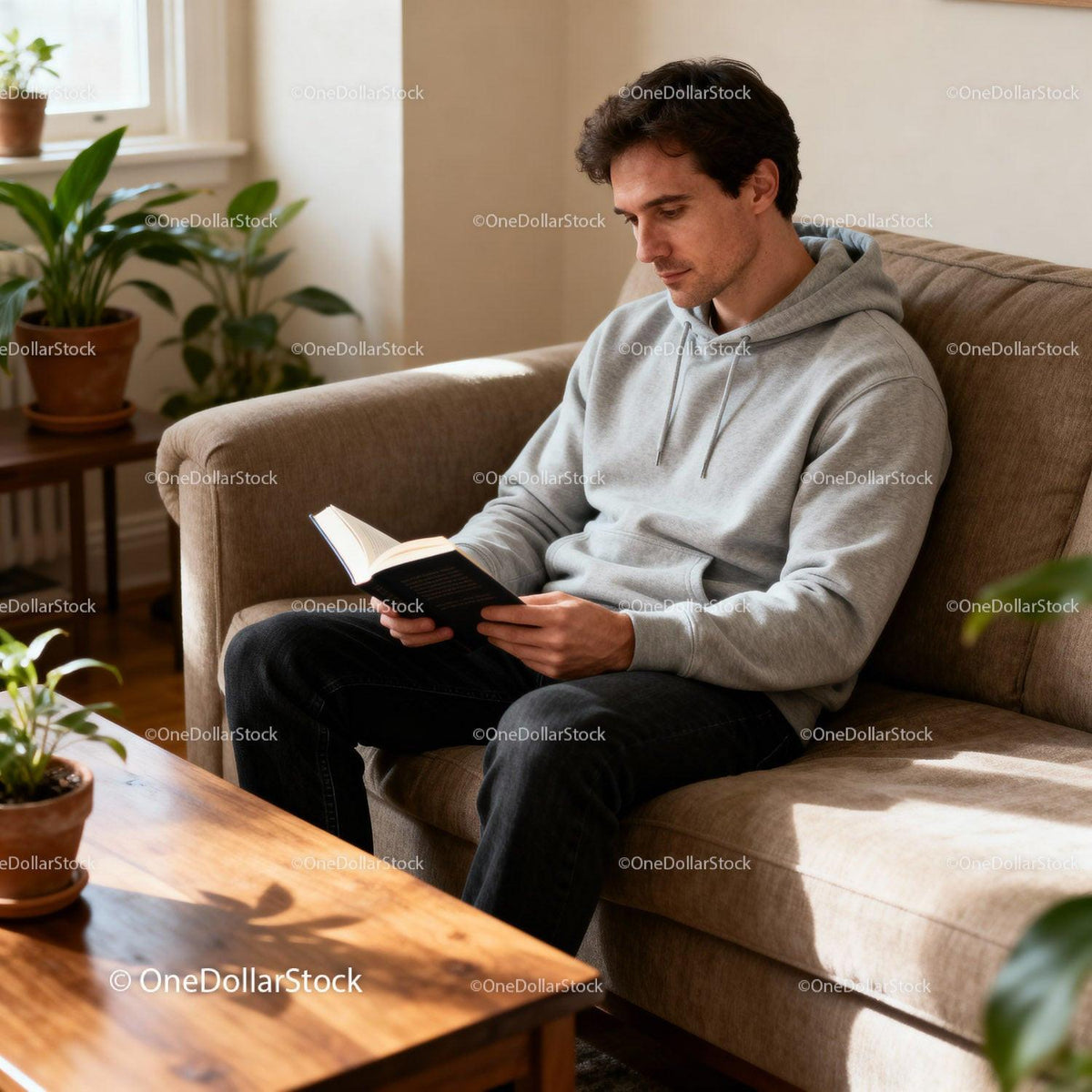 Man in Gray Hoodie Reading Book Relaxing at Home