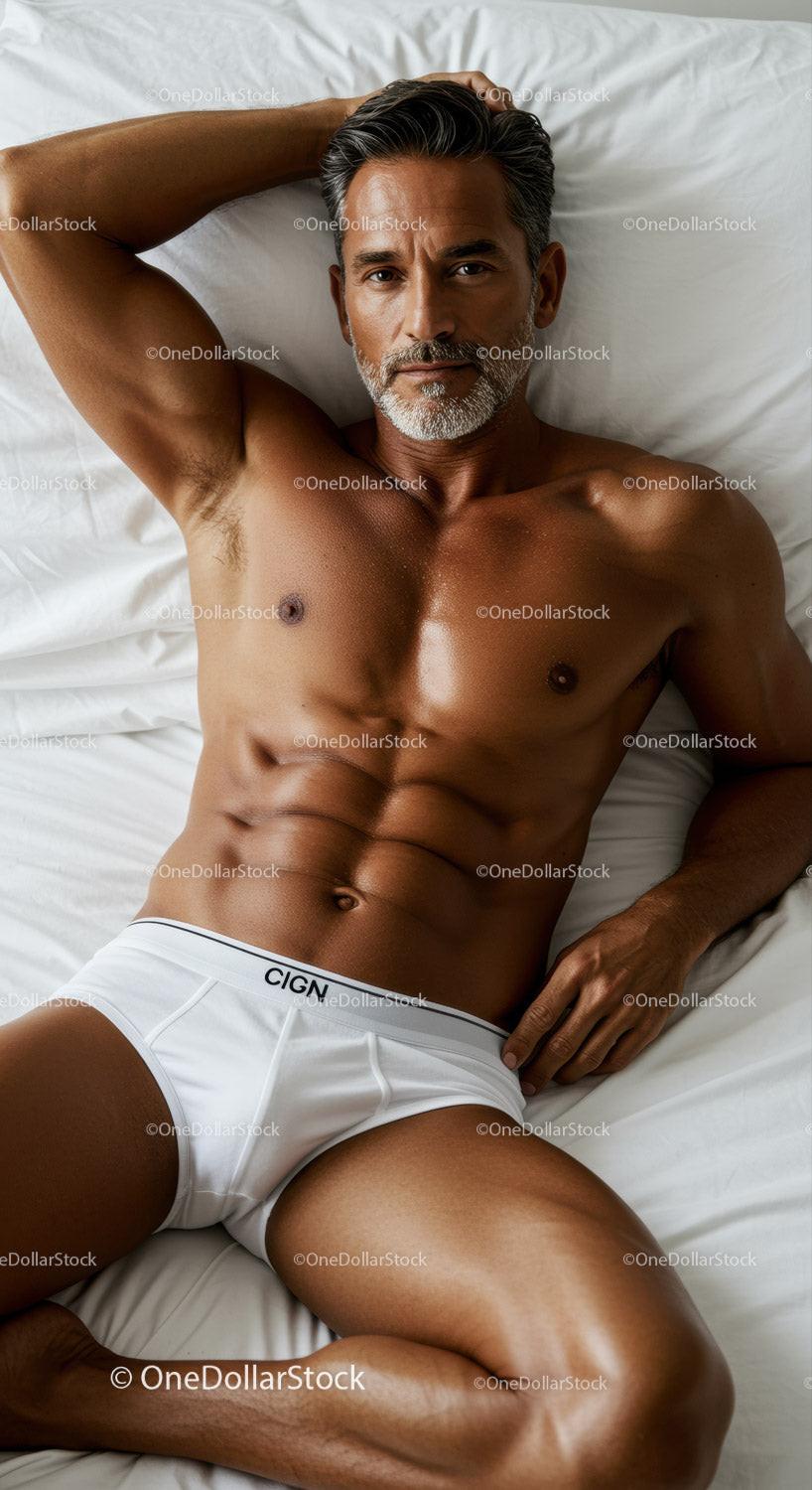 Fit mature man relaxing on bed in white underwear