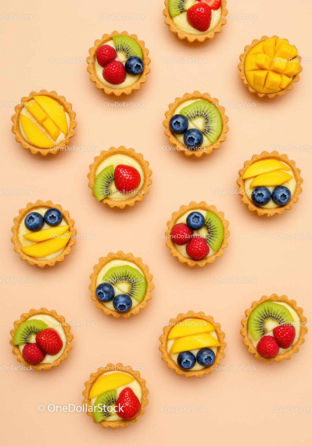 Assorted Mini Fruit Tarts on Peach Background