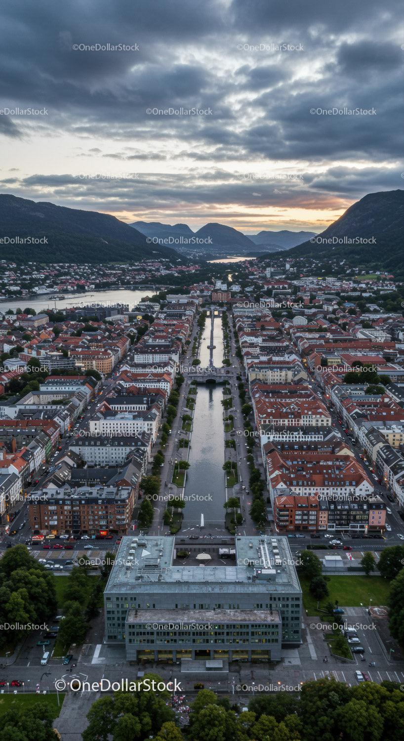 Scenic Mountain Town with River and Modern Buildings at Sunset