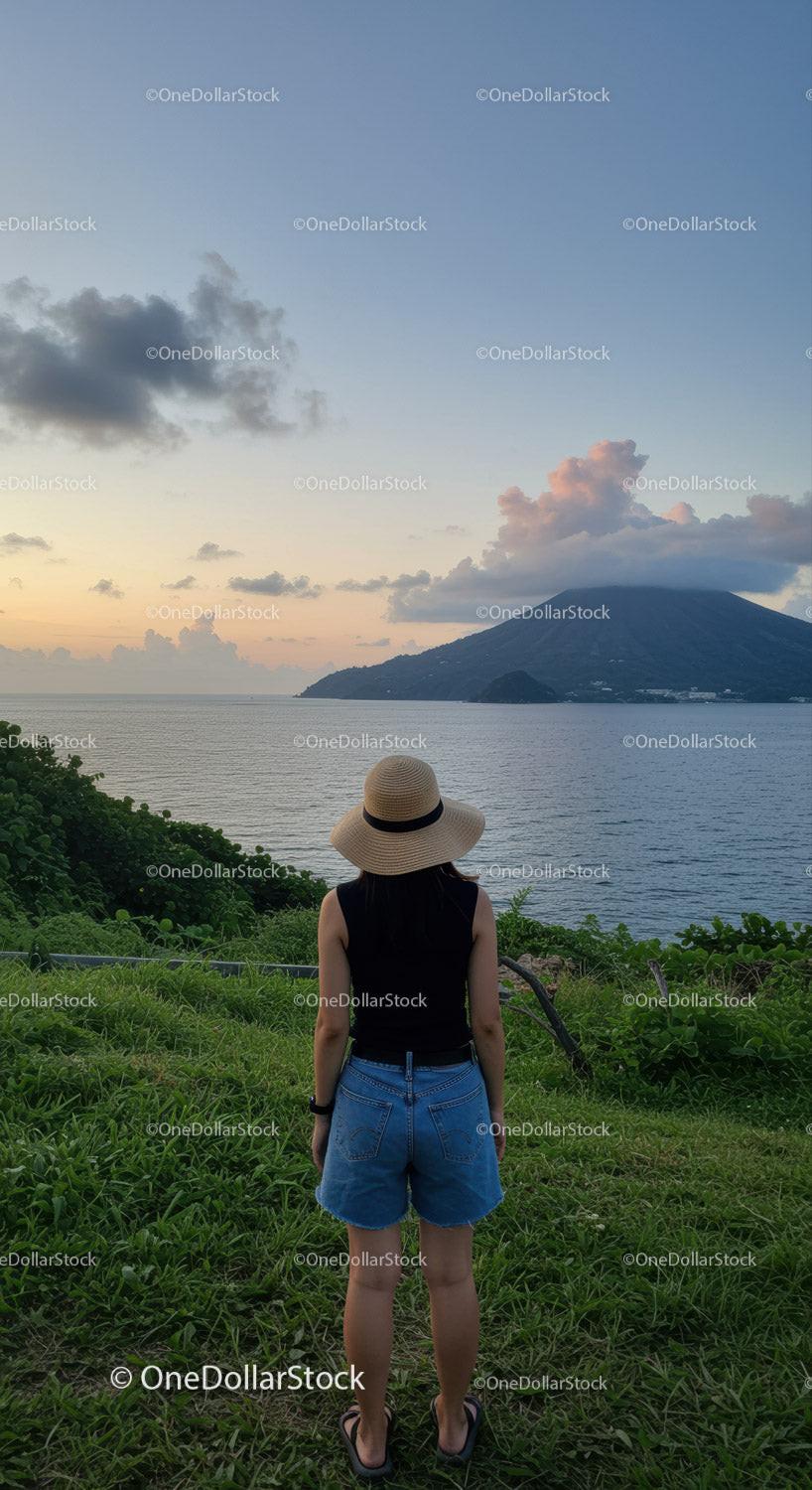 Woman in Summer Clothing Overlooking Ocean and Mountain Landscape