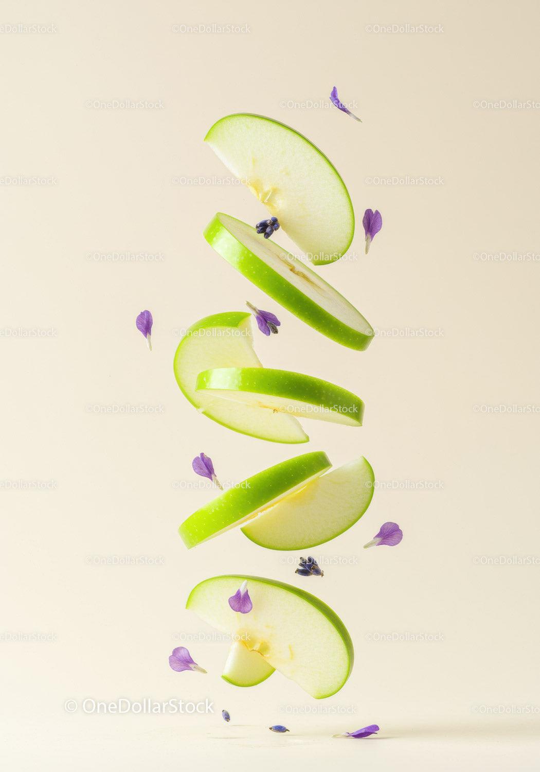 Floating green apple slices with delicate purple flowers