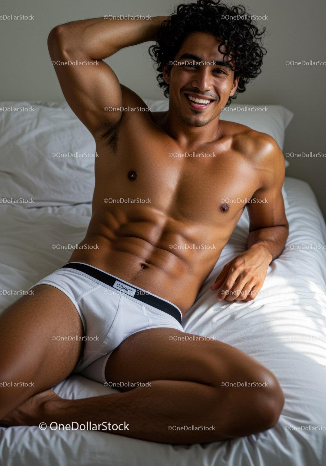 Smiling shirtless man relaxing on white bed