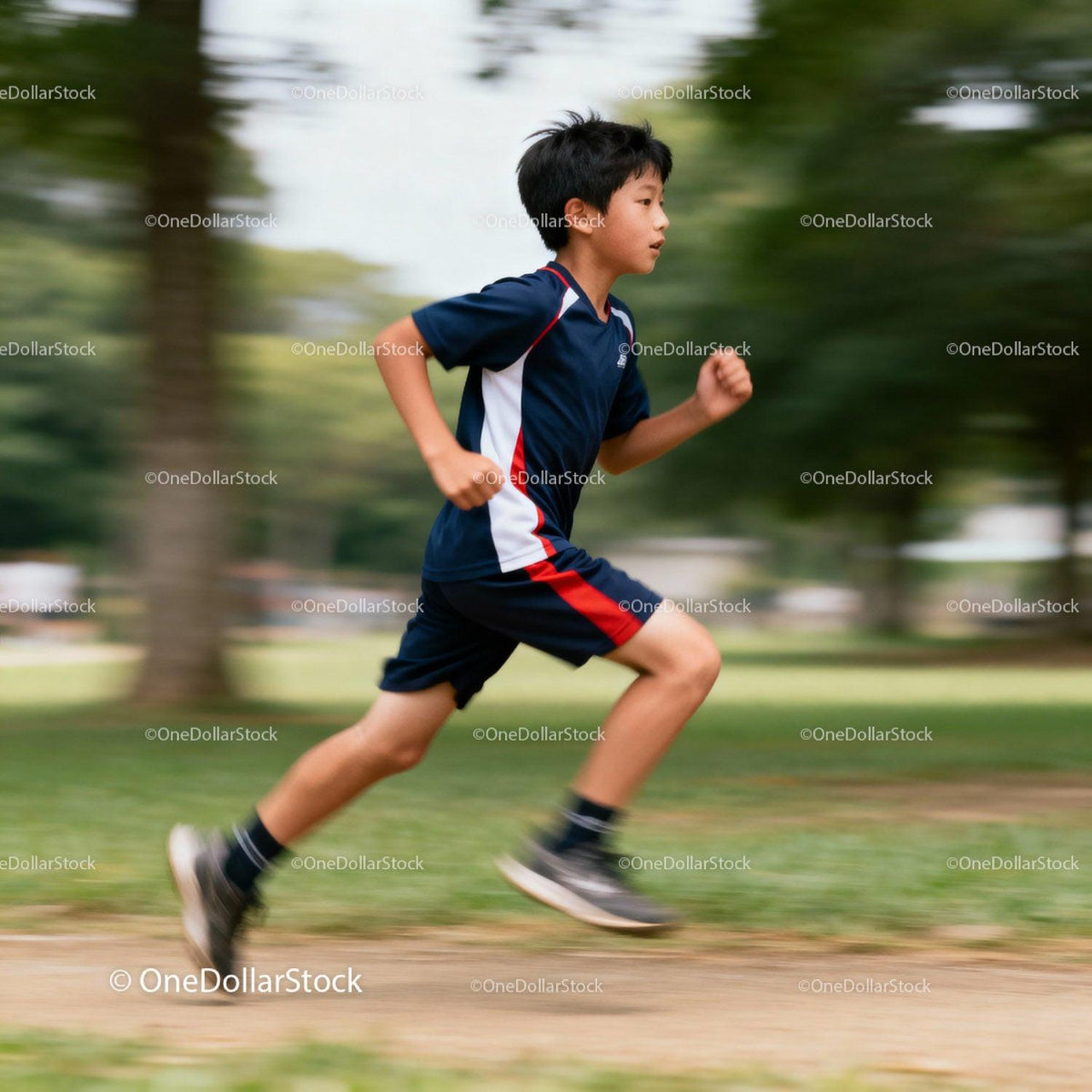 Young boy running energetically through park trail