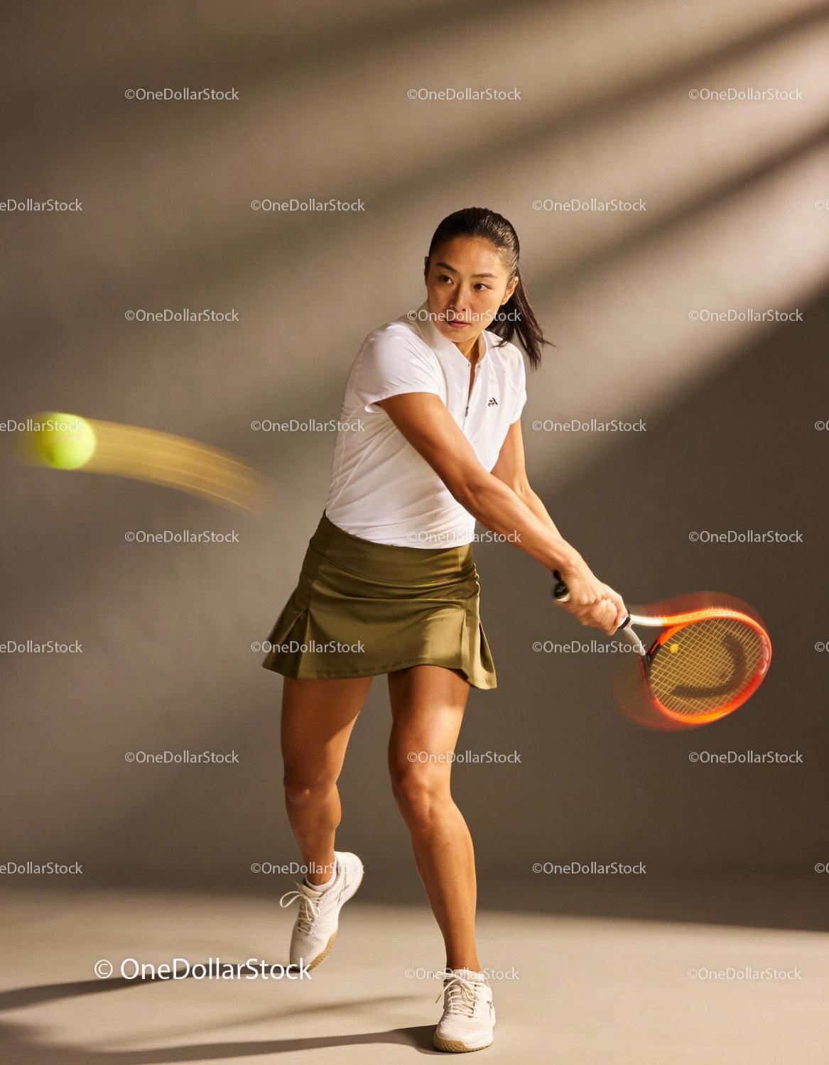 Focused female tennis player hitting a backhand shot