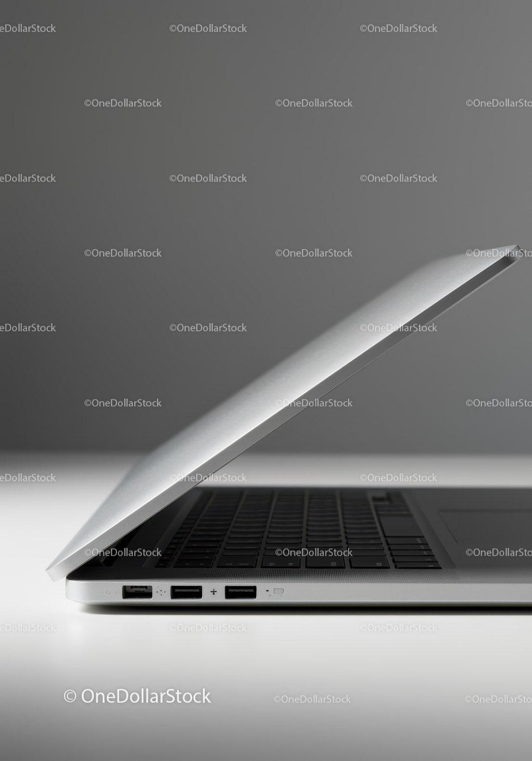 Silver Laptop on White Surface with Gray Background