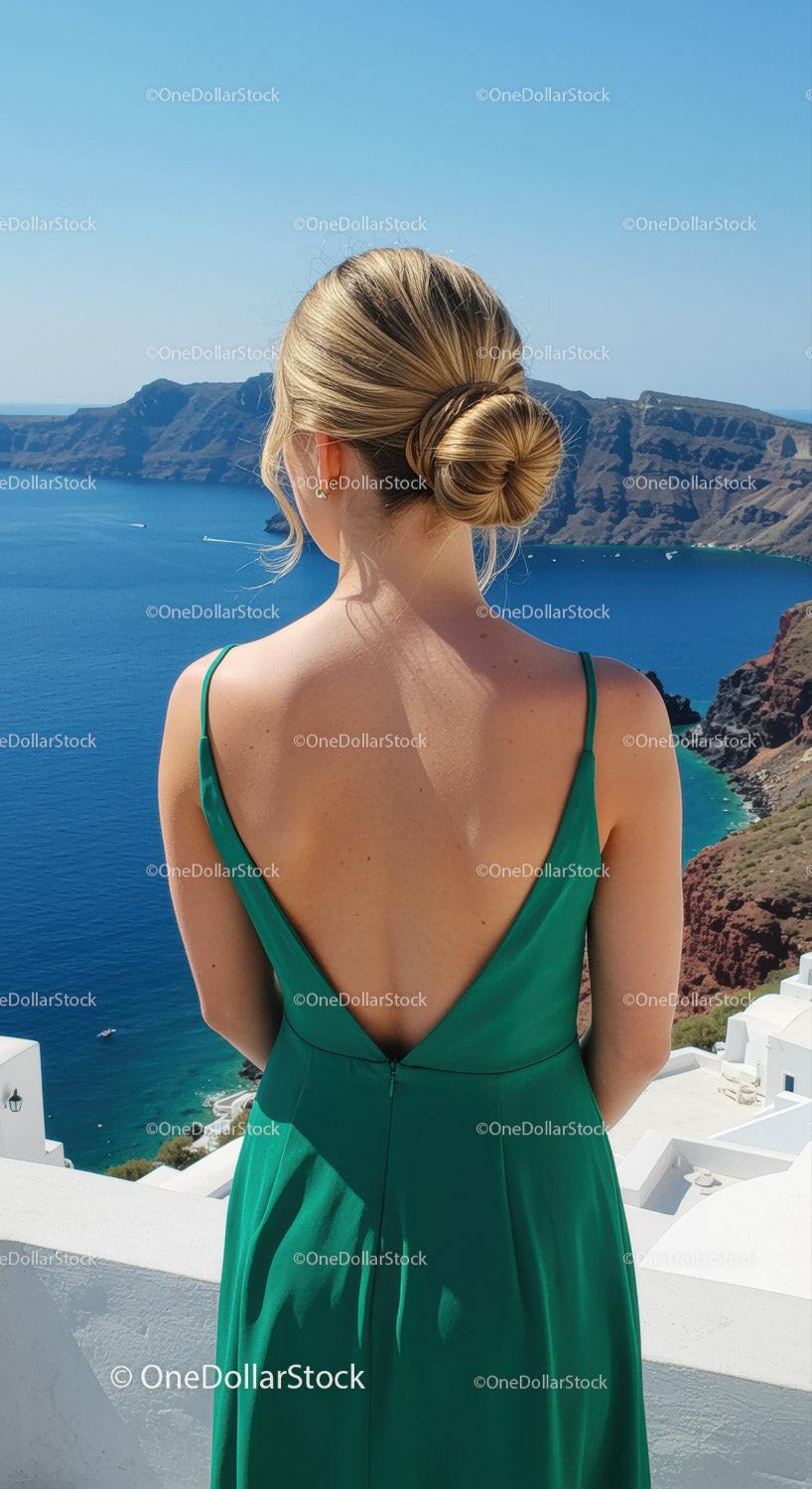 Woman in green dress overlooking serene sea view