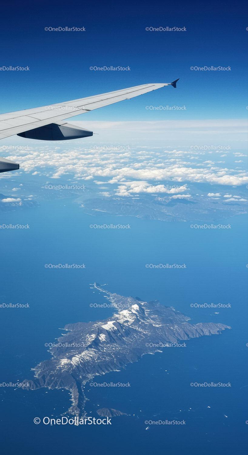 Scenic Aerial View of Snow-Capped Mountains and Ocean from Airplane Window