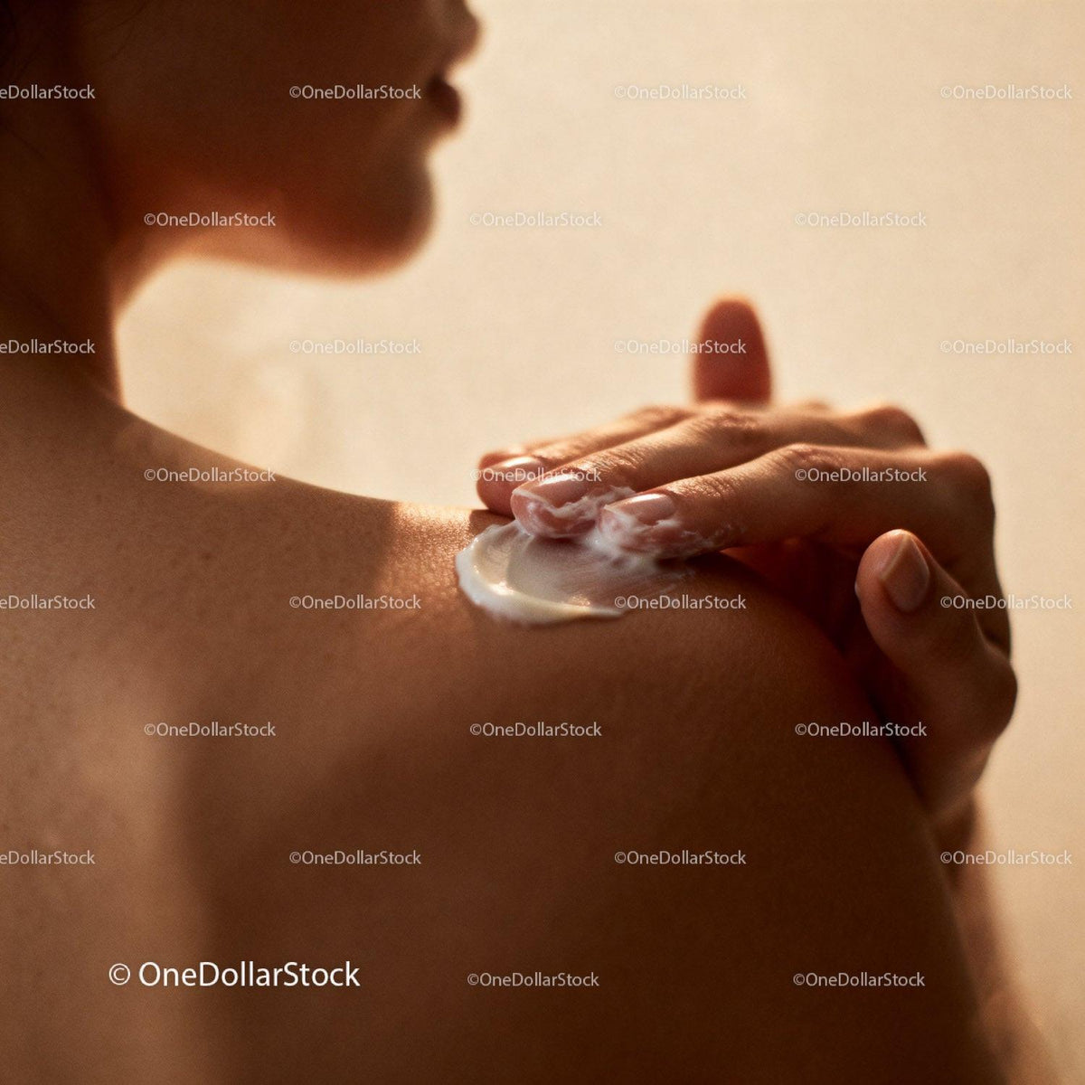Woman Applying Cream on Shoulder in Soft Light