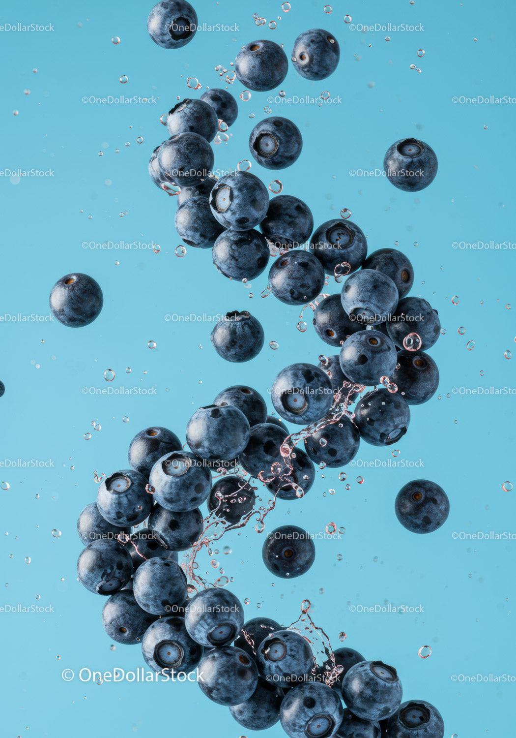 Fresh blueberries splashing in clear blue water