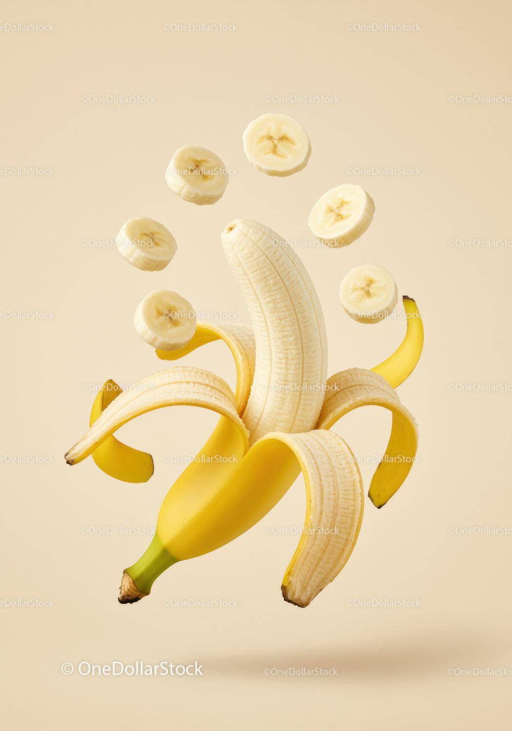 Peeled banana with hovering banana slices on beige background
