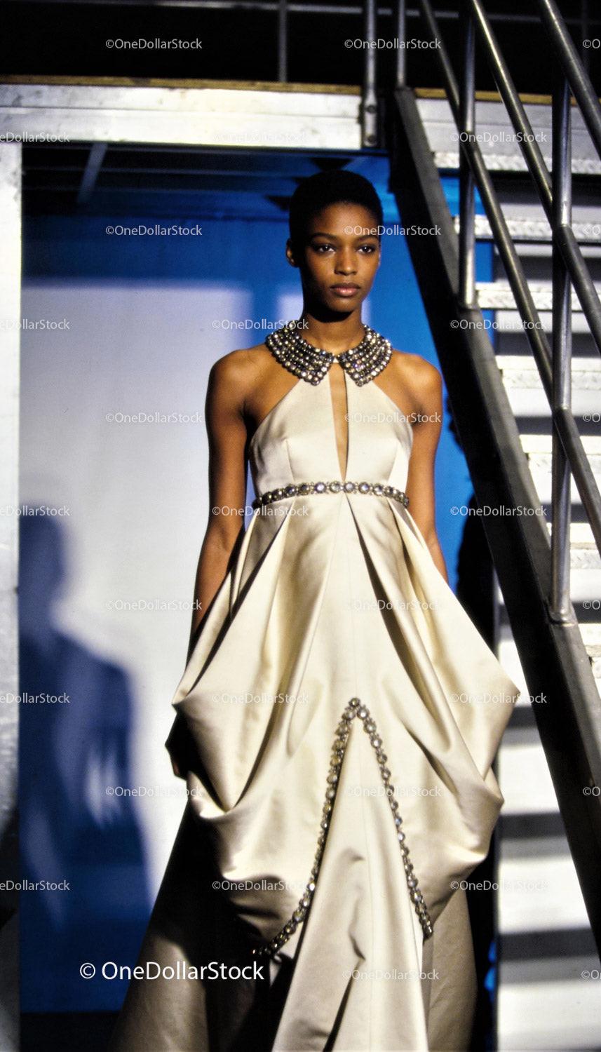 Elegant woman in beaded ivory evening gown by stairs
