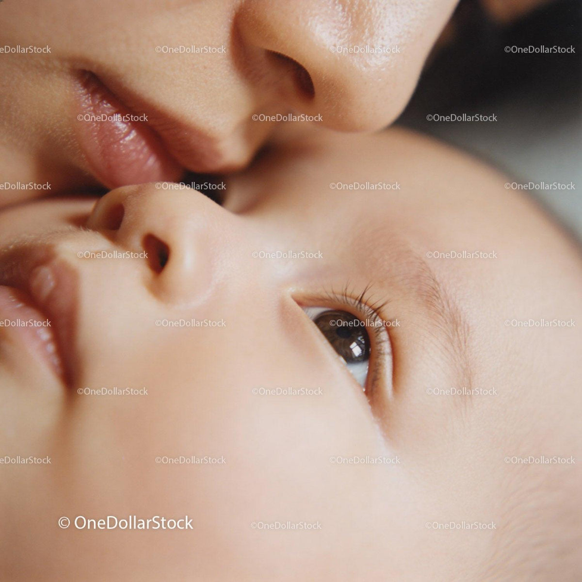 Tender moment of mother kissing newborn baby gently