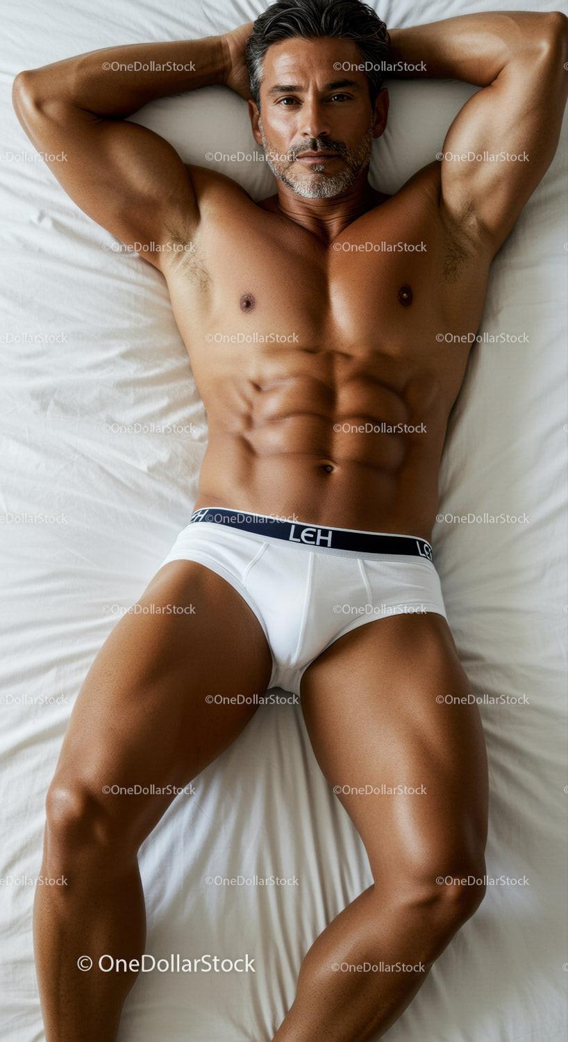 Fit man relaxing on bed in white underwear
