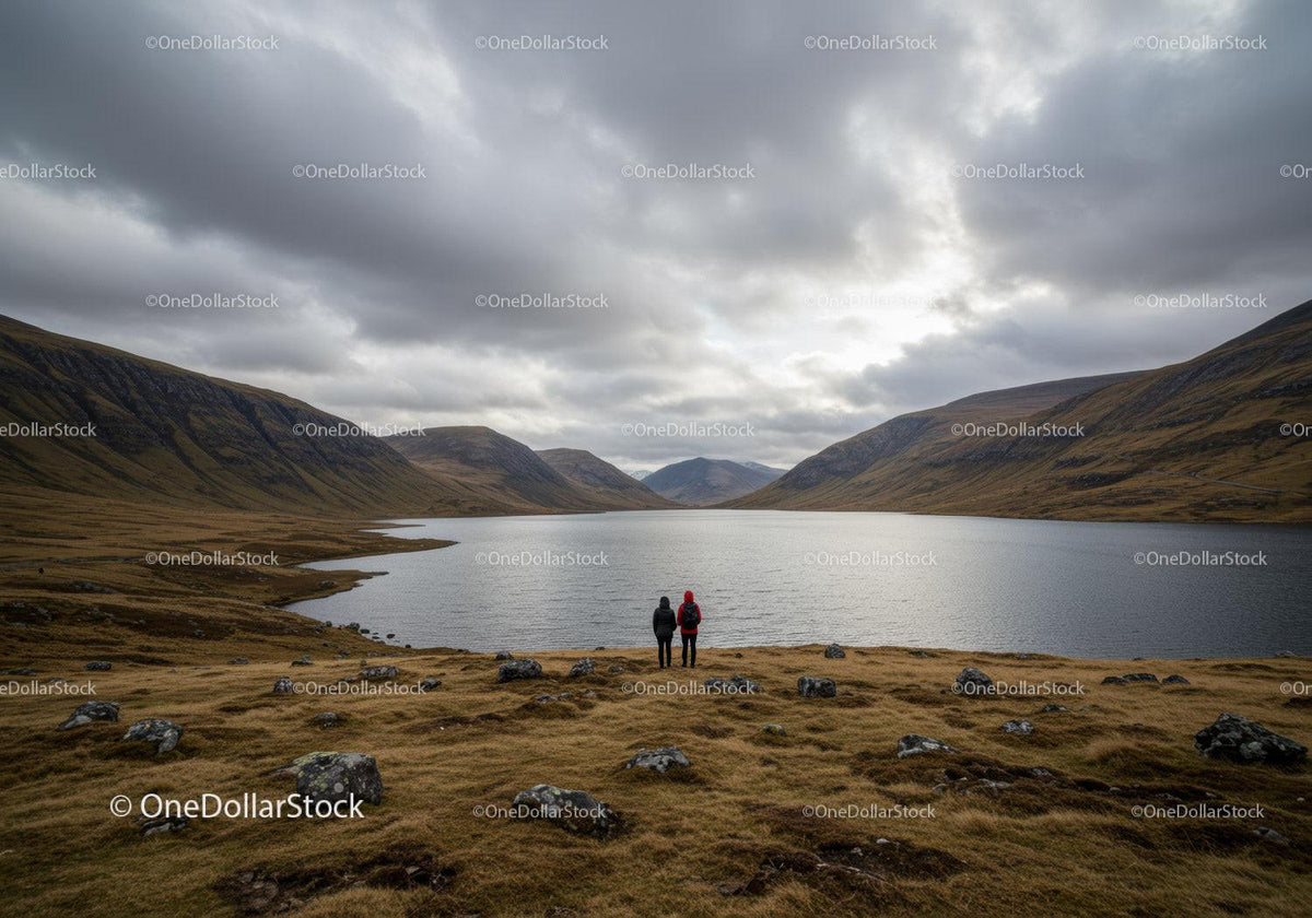 Scenic Mountain Valley Lake with Hikers Under Cloudy Sky
